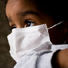 Small child wearing a swine flu mask